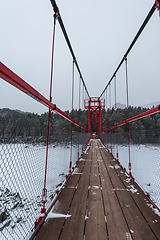 Image showing Suspension hanging bridge above winter frozen river