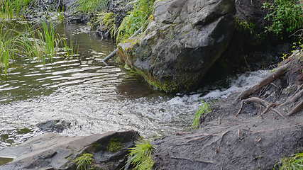 Image showing Big beautiful waterfall flows down the rocks mountains