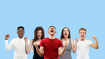 Image showing Portrait of multiethnic group of young people isolated on blue studio background, flyer, collage