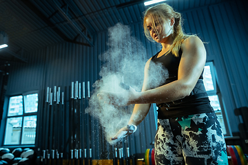 Image showing Caucasian teenage girl practicing in weightlifting in gym