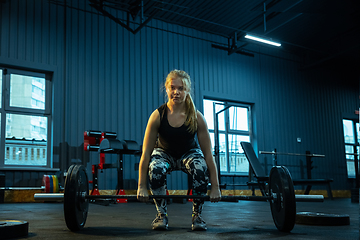 Image showing Caucasian teenage girl practicing in weightlifting in gym