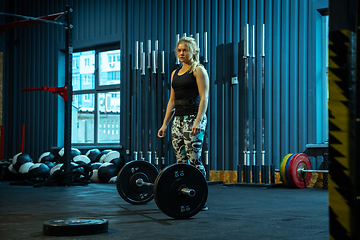 Image showing Caucasian teenage girl practicing in weightlifting in gym