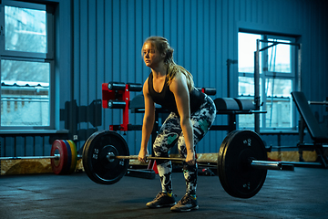 Image showing Caucasian teenage girl practicing in weightlifting in gym