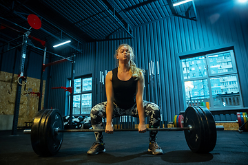 Image showing Caucasian teenage girl practicing in weightlifting in gym