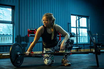 Image showing Caucasian teenage girl practicing in weightlifting in gym