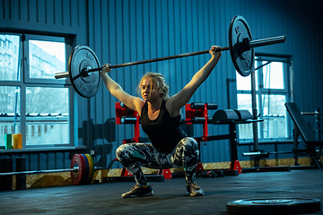 Image showing Caucasian teenage girl practicing in weightlifting in gym