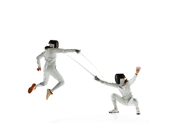 Image showing Teen girls in fencing costumes with swords in hands isolated on white background