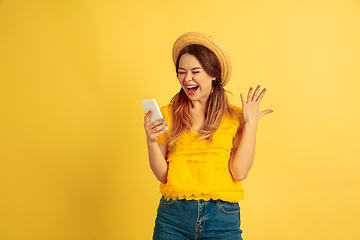 Image showing Caucasian woman\'s portrait isolated on yellow studio background