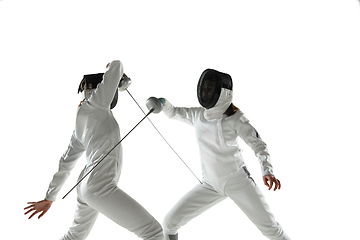 Image showing Teen girls in fencing costumes with swords in hands isolated on white background