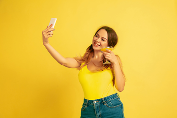 Image showing Caucasian woman\'s portrait isolated on yellow studio background