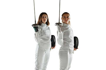 Image showing Teen girls in fencing costumes with swords in hands isolated on white background