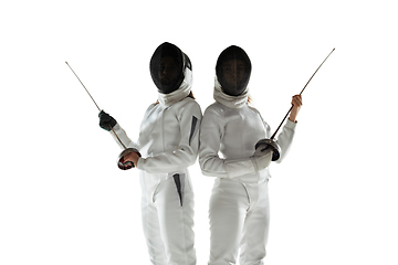 Image showing Teen girls in fencing costumes with swords in hands isolated on white background