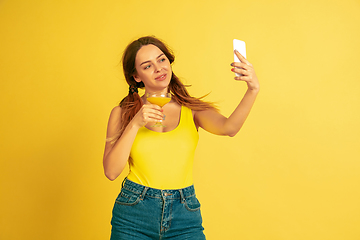 Image showing Caucasian woman\'s portrait isolated on yellow studio background