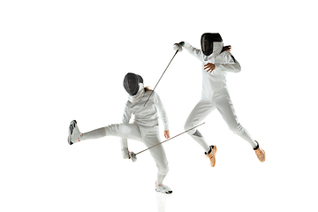 Image showing Teen girls in fencing costumes with swords in hands isolated on white background