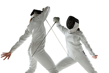 Image showing Teen girls in fencing costumes with swords in hands isolated on white background