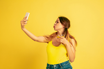 Image showing Caucasian woman\'s portrait isolated on yellow studio background