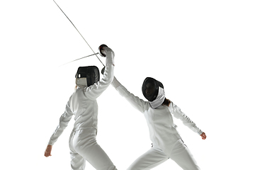 Image showing Teen girls in fencing costumes with swords in hands isolated on white background