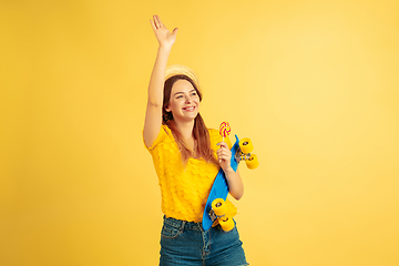 Image showing Caucasian woman\'s portrait isolated on yellow studio background