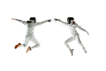 Image showing Teen girls in fencing costumes with swords in hands isolated on white background