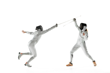 Image showing Teen girls in fencing costumes with swords in hands isolated on white background