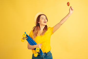 Image showing Caucasian woman\'s portrait isolated on yellow studio background