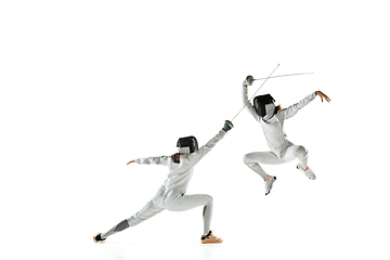 Image showing Teen girls in fencing costumes with swords in hands isolated on white background