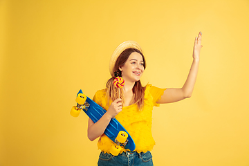 Image showing Caucasian woman\'s portrait isolated on yellow studio background