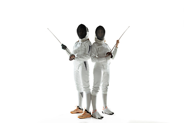 Image showing Teen girls in fencing costumes with swords in hands isolated on white background, flyer