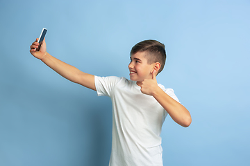 Image showing Caucasian teen\'s portrait isolated on blue studio background