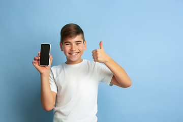 Image showing Caucasian teen\'s portrait isolated on blue studio background