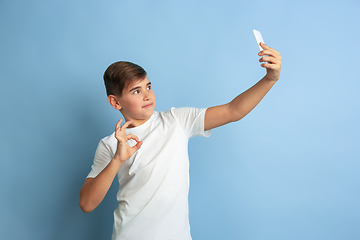 Image showing Caucasian teen\'s portrait isolated on blue studio background