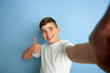 Image showing Caucasian teen\'s portrait isolated on blue studio background