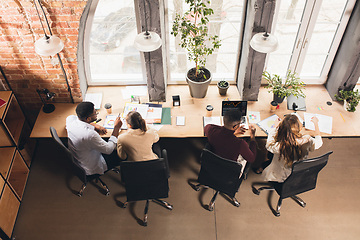 Image showing Colleagues working together in modern office using devices and gadgets during negotiations. Top view.