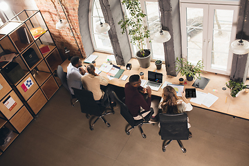 Image showing Colleagues working together in modern office using devices and gadgets during negotiations. Top view.