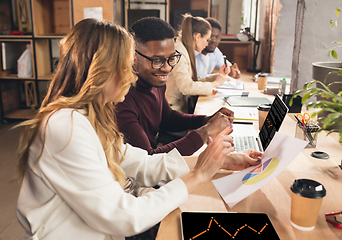 Image showing Colleagues working together in modern office using devices and gadgets during negotiations