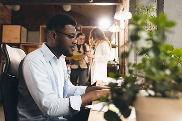 Image showing Colleagues working together in modern office using devices and gadgets during negotiations