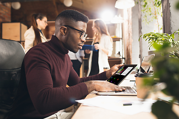 Image showing Colleagues working together in modern office using devices and gadgets during negotiations