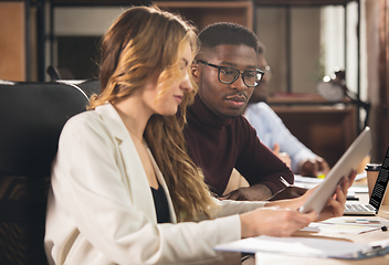 Image showing Colleagues working together in modern office using devices and gadgets during negotiations