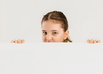 Image showing Caucasian girl isolated on white studio background. Copyspace. Childhood, education, emotions concept