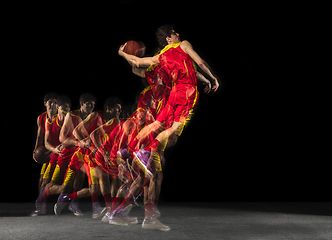 Image showing Young caucasian basketball player in motion and action in mixed light on dark background. Concept of healthy lifestyle, professional sport, hobby.