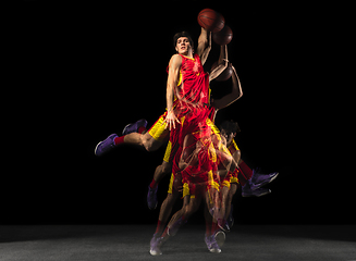 Image showing Young caucasian basketball player in motion and action in mixed light on dark background. Concept of healthy lifestyle, professional sport, hobby.