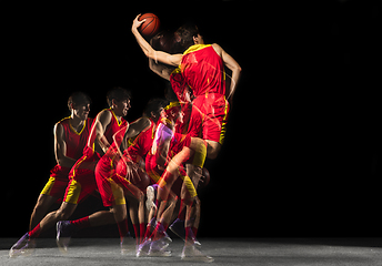 Image showing Young caucasian basketball player in motion and action in mixed light on dark background. Concept of healthy lifestyle, professional sport, hobby.