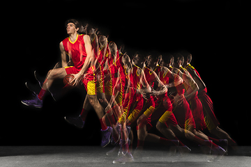 Image showing Young caucasian basketball player in motion and action in mixed light on dark background. Concept of healthy lifestyle, professional sport, hobby.