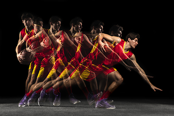 Image showing Young caucasian basketball player in motion and action in mixed light on dark background. Concept of healthy lifestyle, professional sport, hobby.