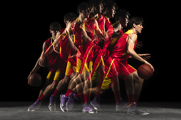 Image showing Young caucasian basketball player in motion and action in mixed light on dark background. Concept of healthy lifestyle, professional sport, hobby.