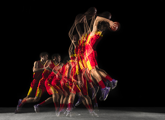 Image showing Young caucasian basketball player in motion and action in mixed light on dark background. Concept of healthy lifestyle, professional sport, hobby.