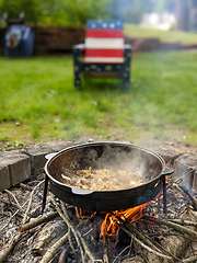 Image showing gourmet beef stew cooked in cauldron on outdoor fire pit