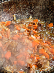 Image showing gourmet beef stew cooked in cauldron on outdoor fire pit