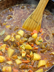 Image showing gourmet beef stew cooked in cauldron on outdoor fire pit