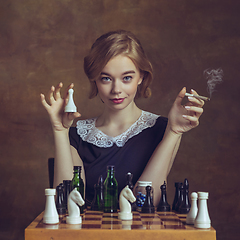 Image showing Young woman in art action isolated on brown background. Retro style, comparison of eras concept.